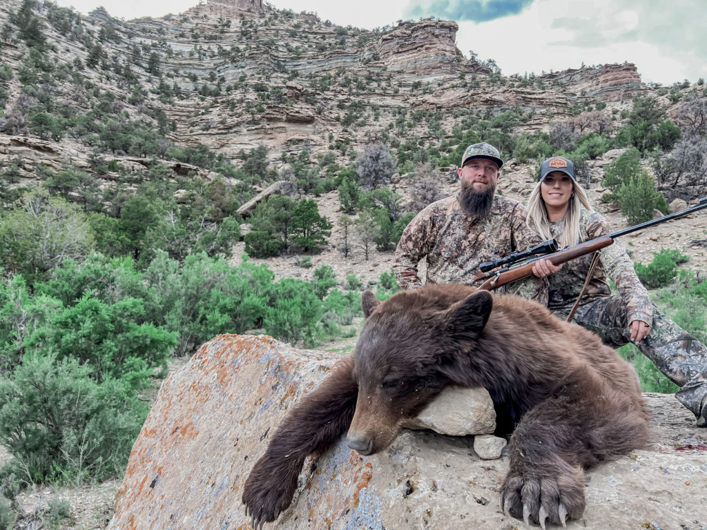 Cody and Brittney Long (man and woman) in King's Camouflage with Utah Black Bear that he harvested. 